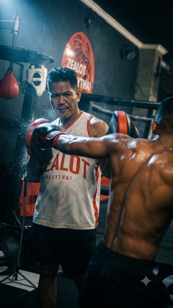 Coach Jerry holding pads at Zealot Muay Thai